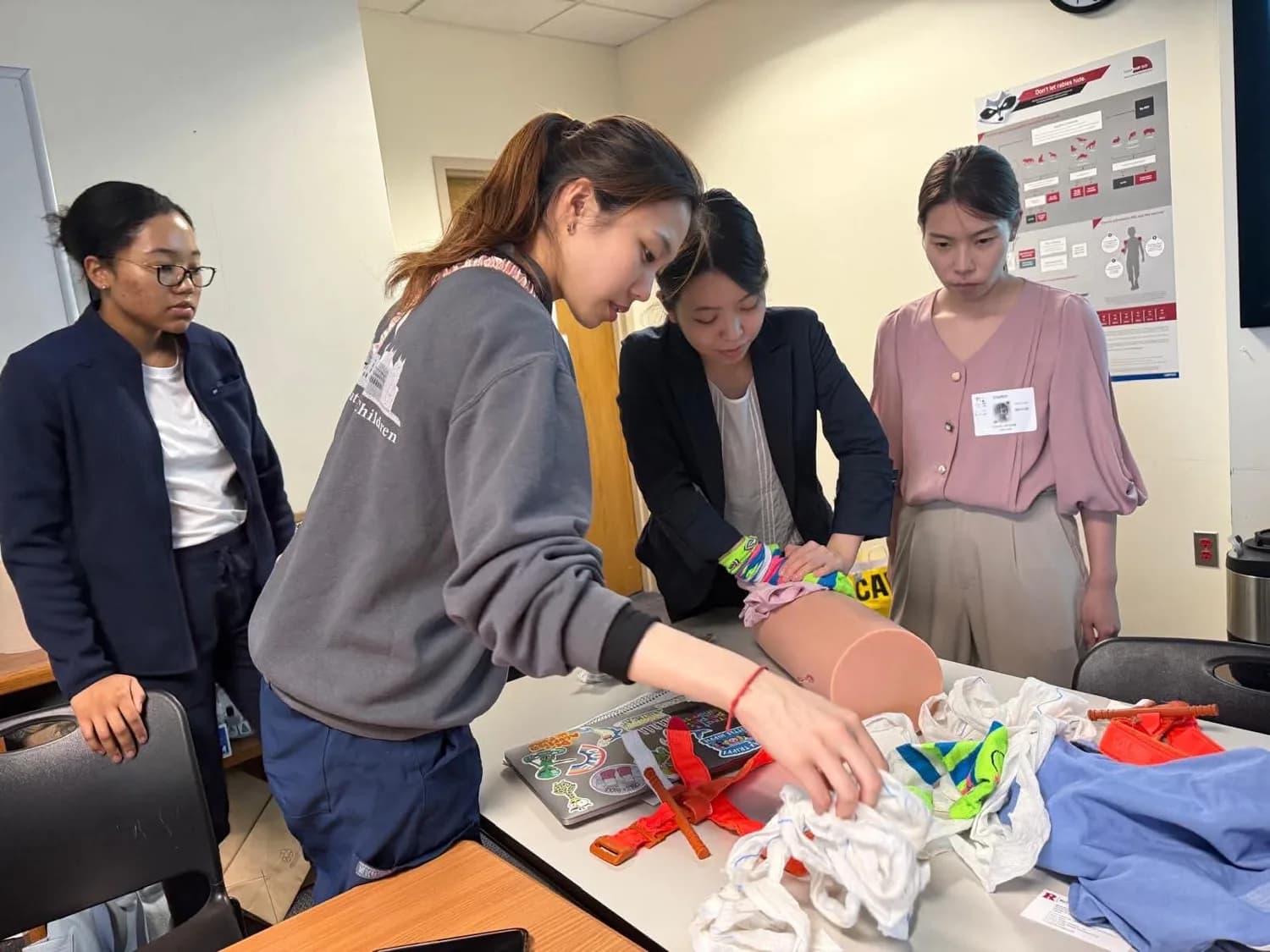 A group practicing with a medical training mannequin and emergency supplies.