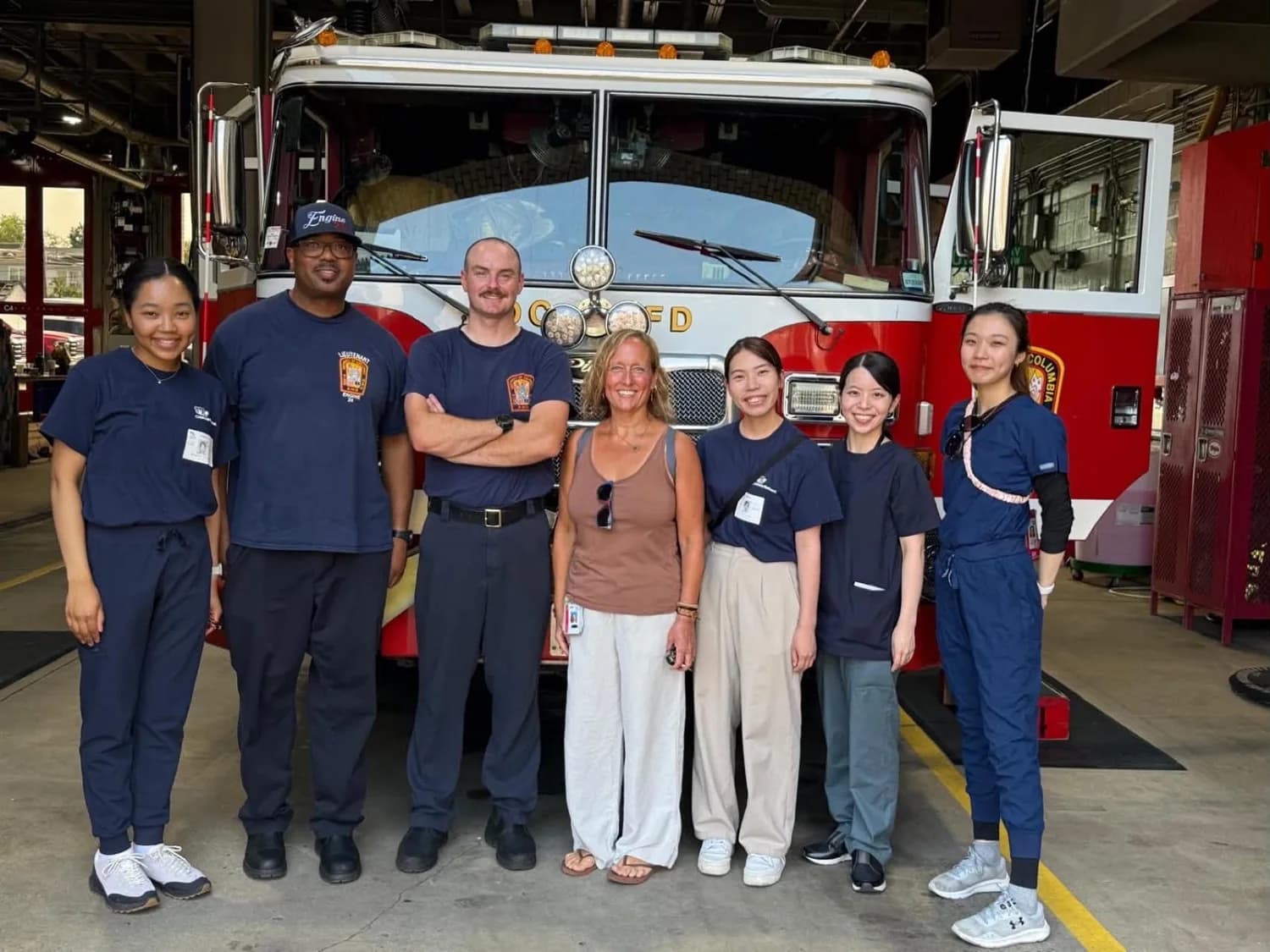 Participants and hosts together in front of a fire engine.