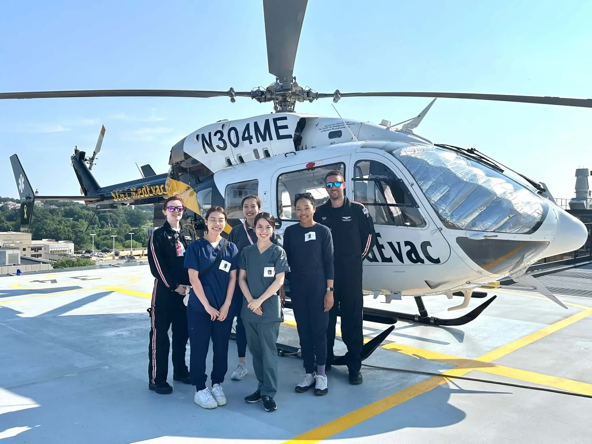 Nurses and medical transport professionals together beside a medical helicopter.