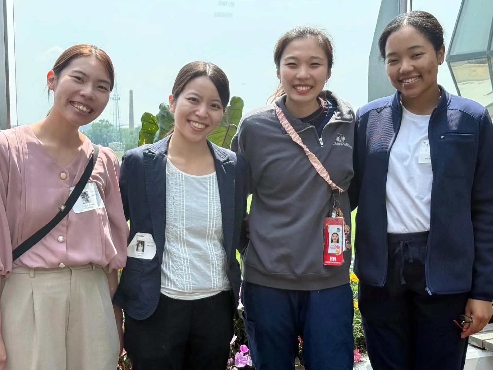 Four participants smiling together outdoors during a hospital visit.